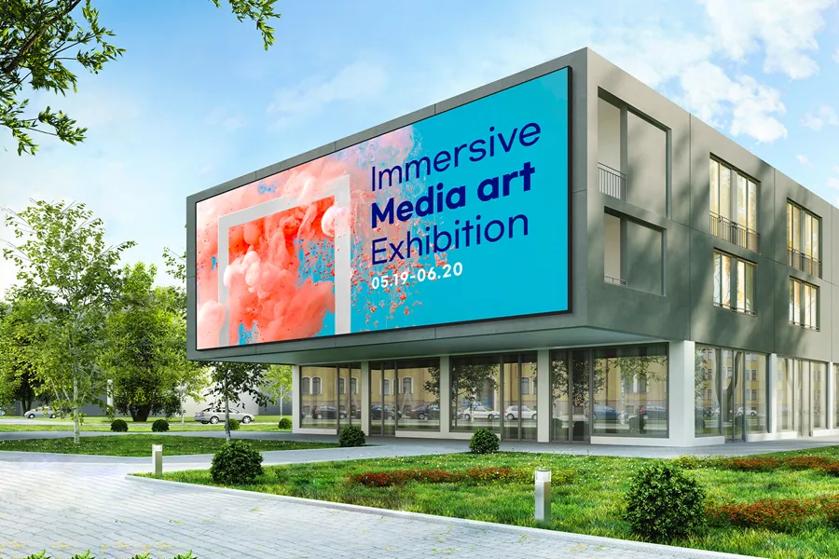 Modern building with a large billboard advertising an art exhibition.