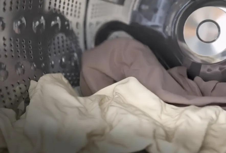Close-up view of the inside of a washer filled with sheets.