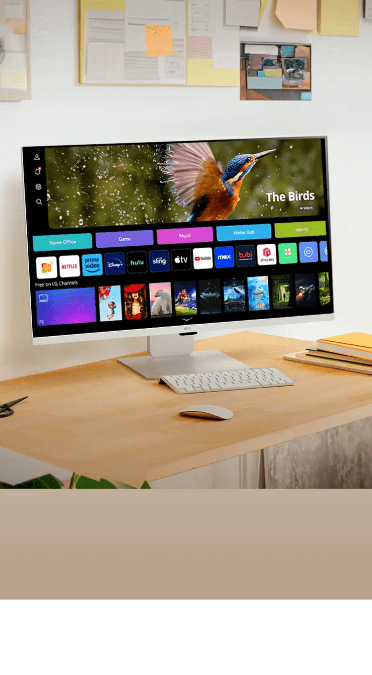 LG Smart Monitor on a wooden desk in a bright, plant-filled home office.