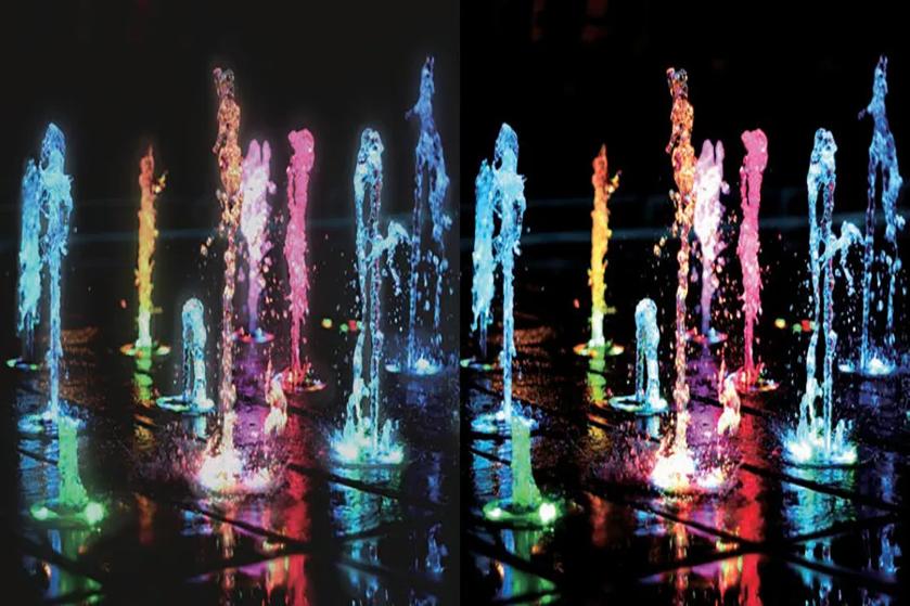 Colorful illuminated water fountains at night, with vibrant reflections.