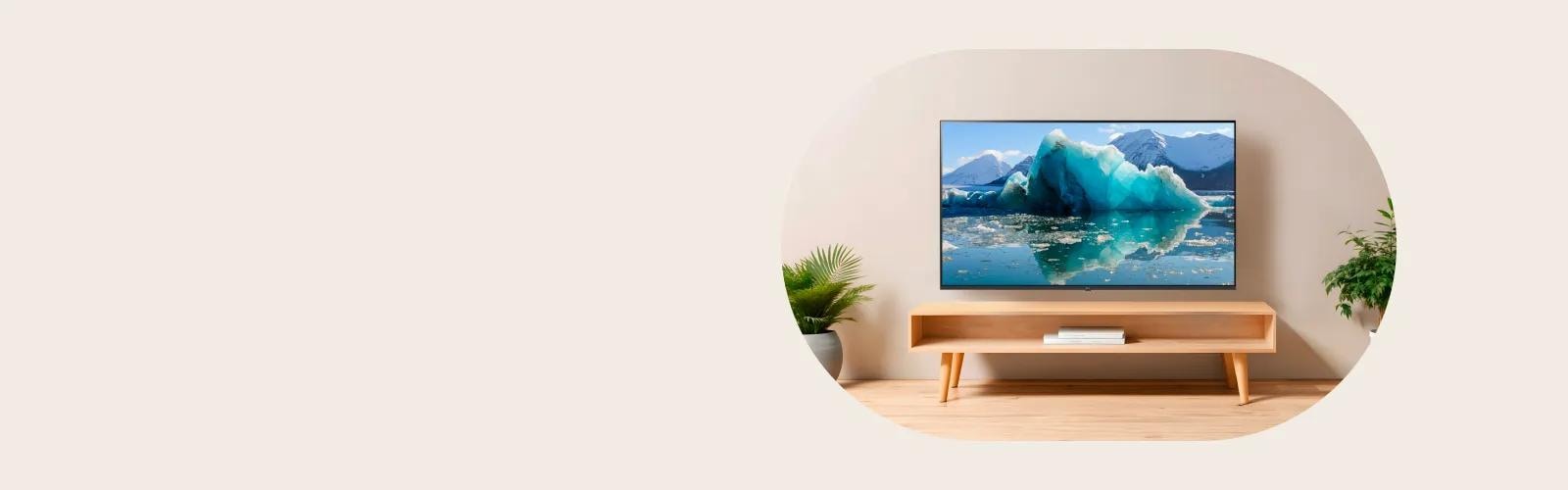 LG OLED TV on a wooden console displaying a vivid glacier scene in a minimalist living room with plants.