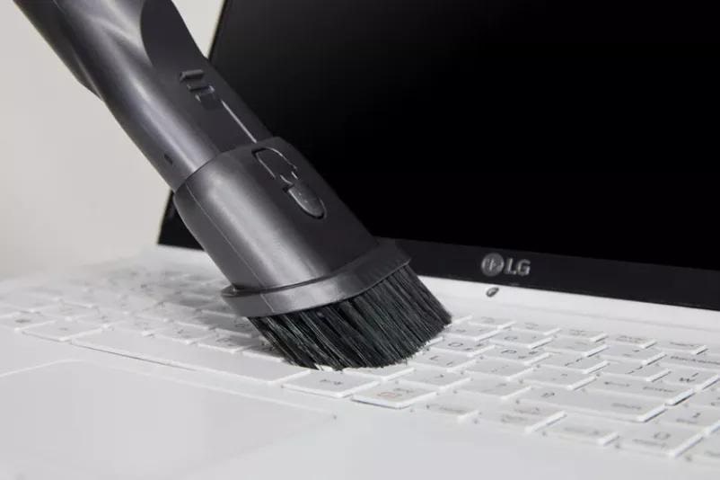 2-in-1 Combination Tool on LG CordZeroTM A9 Vacuum cleaner cleaning laptop.
