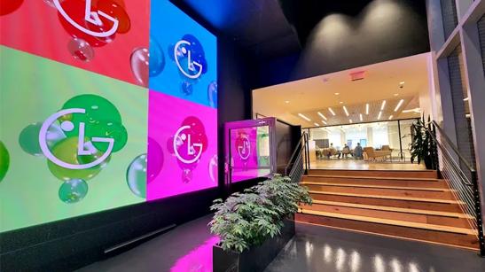 Interior of the LG Business Innovation Center in Washington DC. To the right, a set of stairs lead to the BIC's conference or meeting room, while to the left, the LG logo is rendered in bold colors on a large DVLED wall display. 