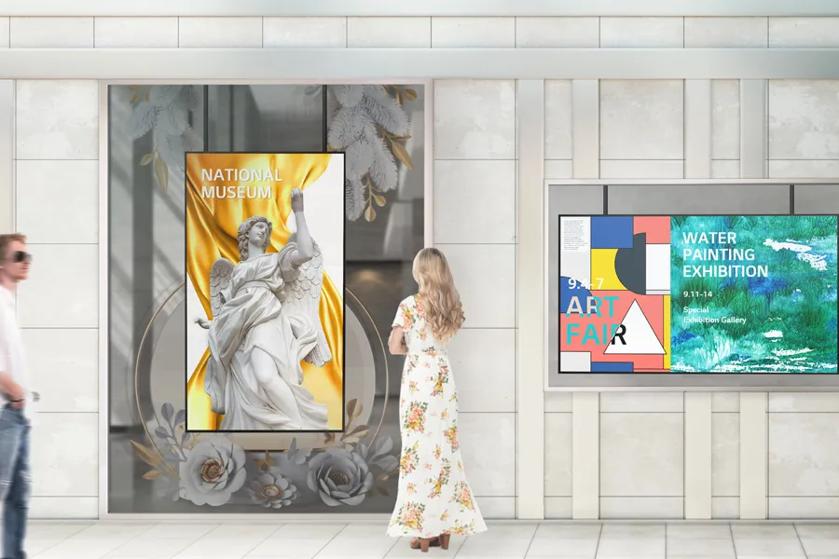 Art gallery guests look at lobby signage featuring new art show ads.