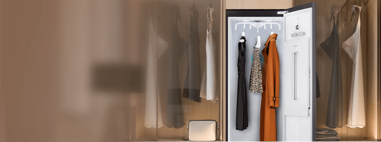 Open LG Styler® shown with various garments hanging inside, including a coat, dress and top, demonstrating its sleek design and garment-refreshing capabilities.