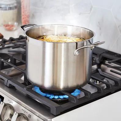A pot of water boils on an gas stovetop.
