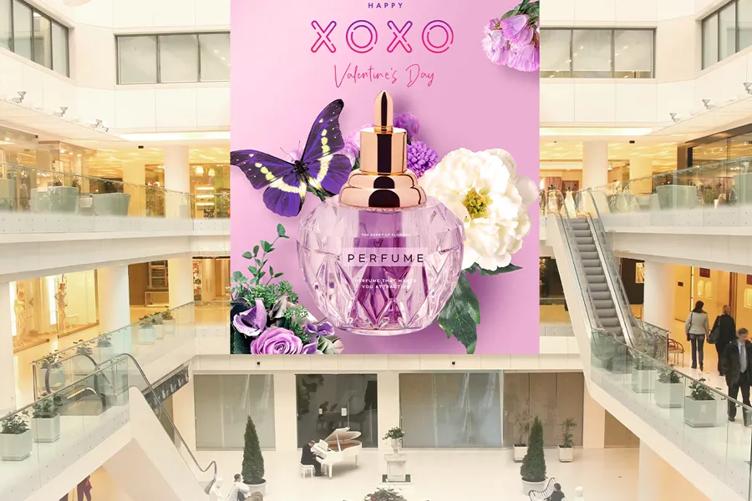 A large advertisement for a perfume brand is displayed in the central space of a shopping mall on LG Value Series DVLED.
