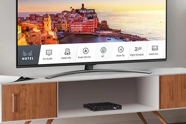 An LG Pro:Centric set top box on the shelf of a TV stand. An LG Hotel TV is on the top of the TV stand.