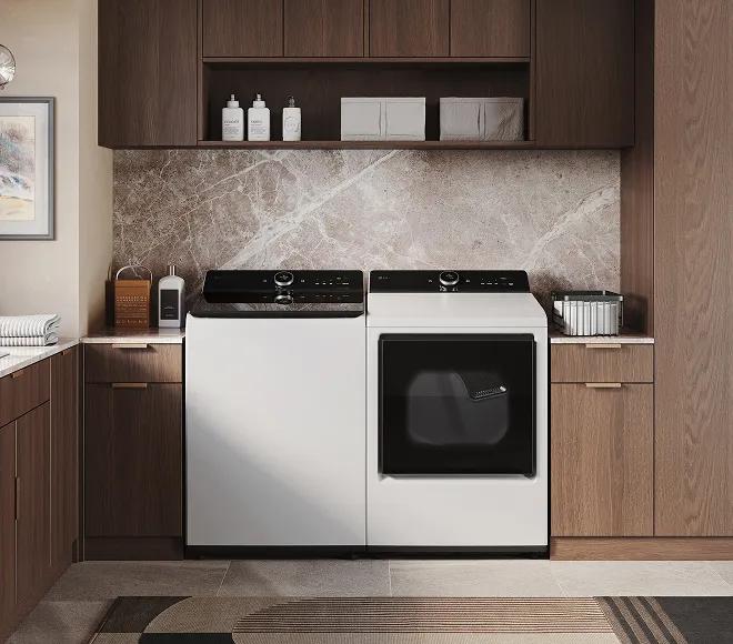 White top-load washer and white front-load dryer in a modern laundry room with brown cabinets around it.