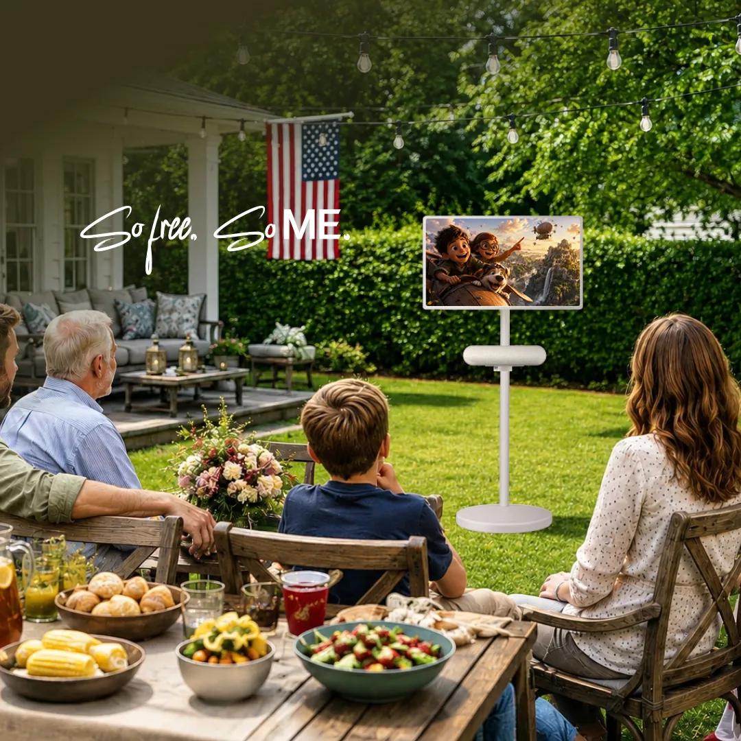 LG portable TV on a stand outdoors as a family watches during a backyard Labor Day gathering with food on the table, with text reading So free. So ME.