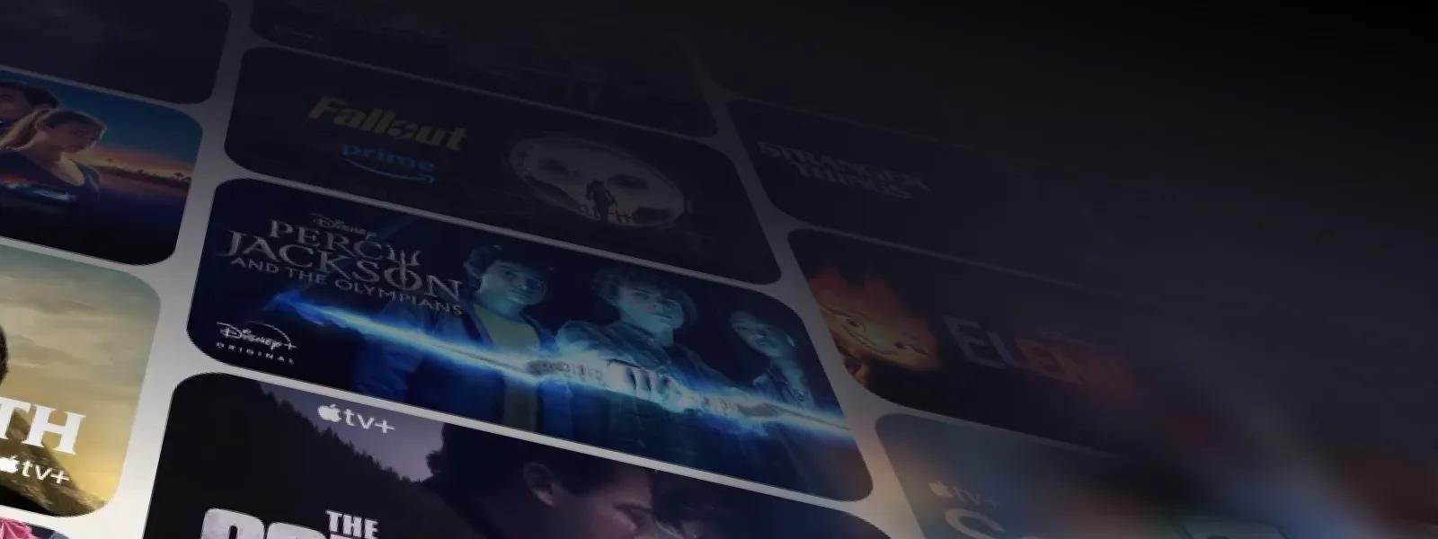 An animated scrolling of columns of streaming titles from different services, like Disney+'s 'Percy Jackson and the Olympians,' Prime Video's 'Fallout,' and Apple TV+ and Netflix titles.