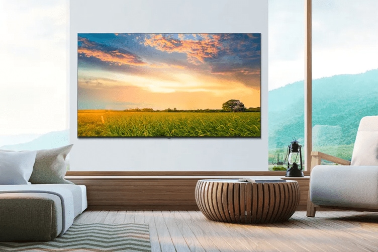 A modern upscale hotel room, with an LG Pro:Centric Hotel TV. The TV shows a brightly colored sunset over a vivid green field.