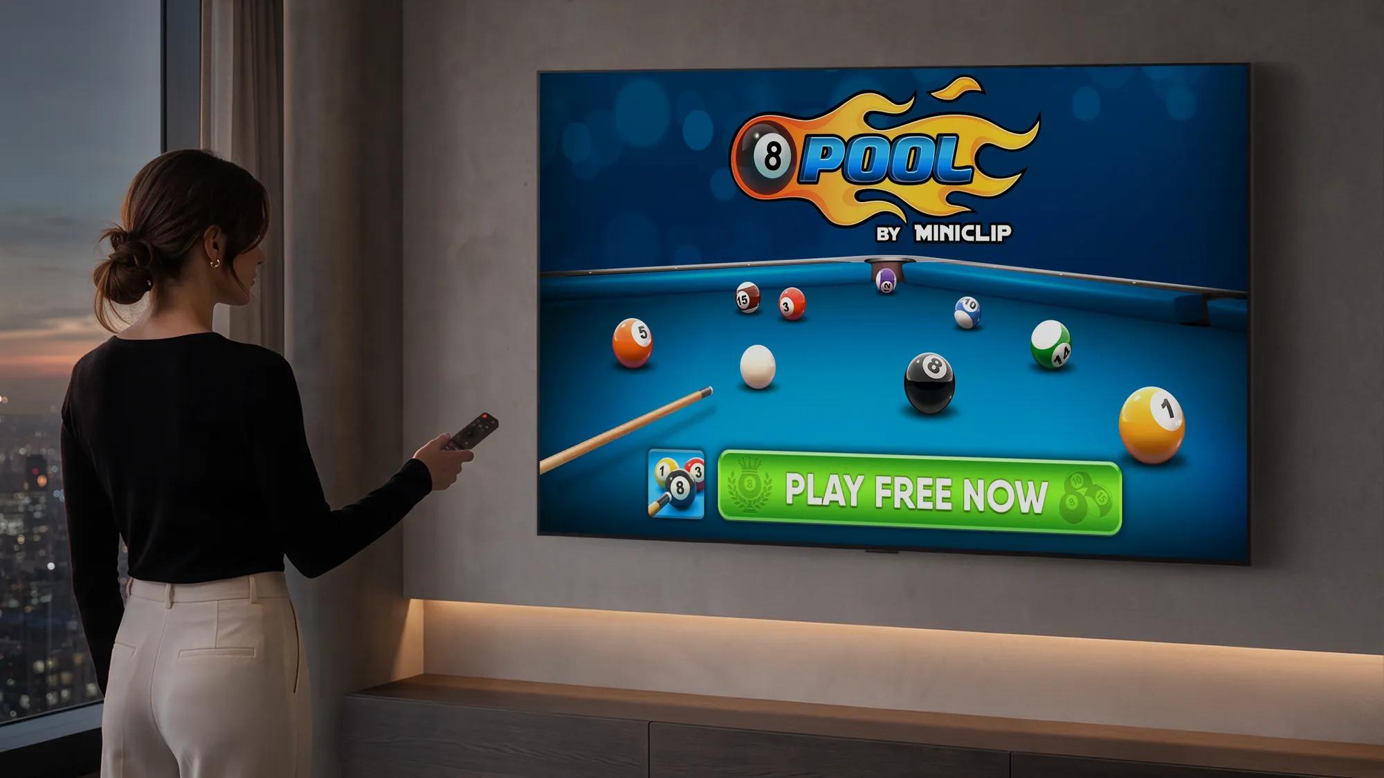 Woman pointing a remote at a wall-mounted LG TV displaying "8 Pool by Miniclip" with a "Play Free Now" button, in a modern apartment living room with floor-to-ceiling windows overlooking a city skyline at dusk.