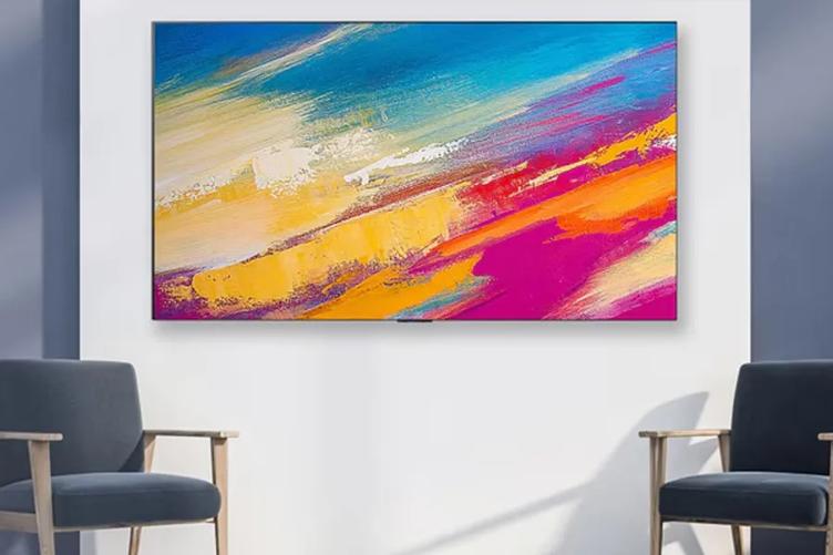 A modern upscale hotel room, with an LG Pro:Centric SMART Hotel TV. The TV displays a bright abstract painting on its screen. 