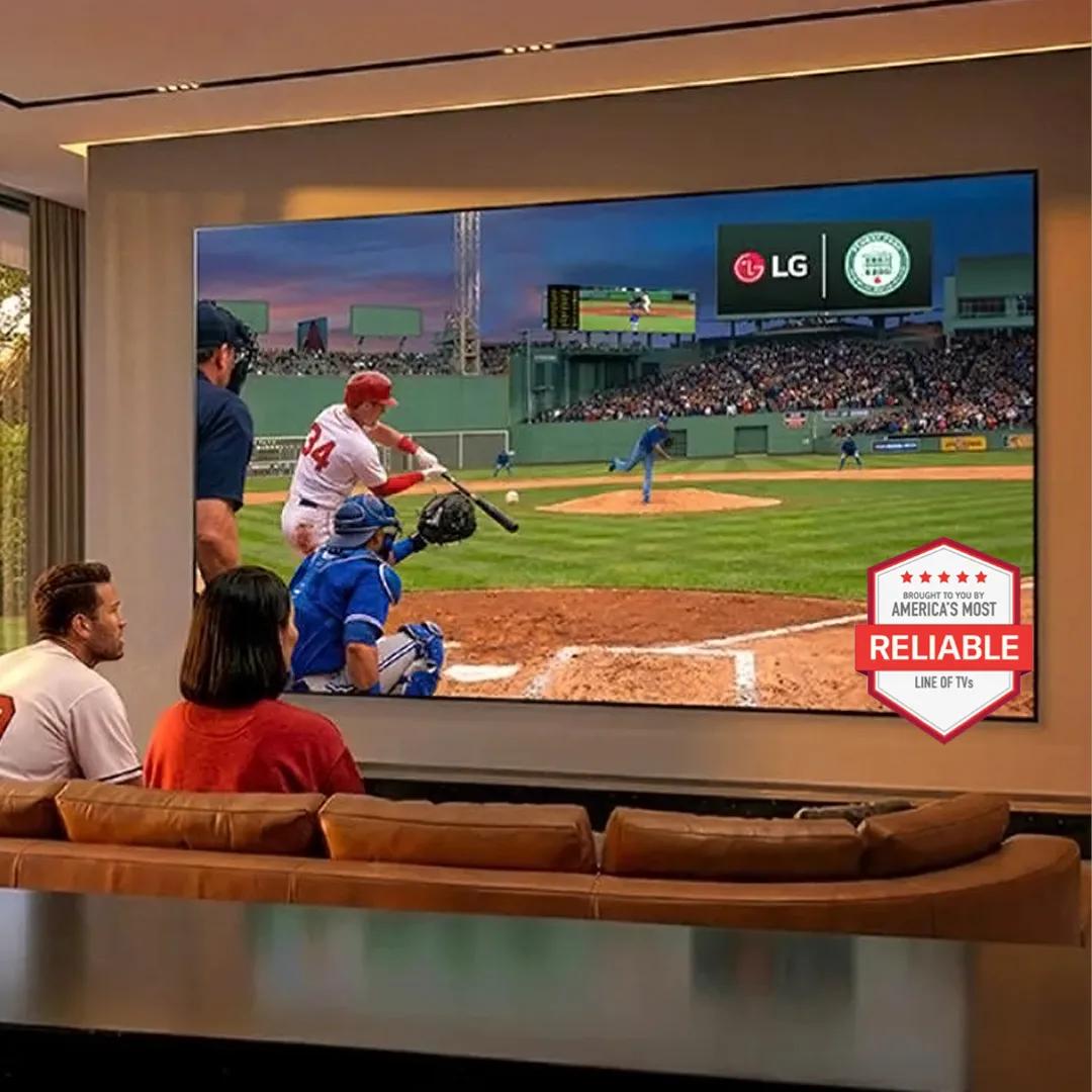 A man and woman watching a baseball game on a big screen TV.