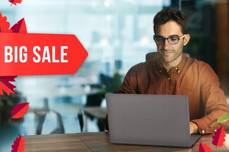 A businessman works on an LG gram laptop in a sleek modern office. On the left of the image is a bold red tag with the words Big Sale, surrounded by bright red cartoon fall leaves.
