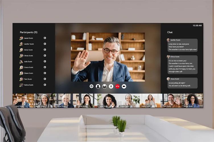 A virtual meeting on a large screen, featuring multiple participants and chat messages.