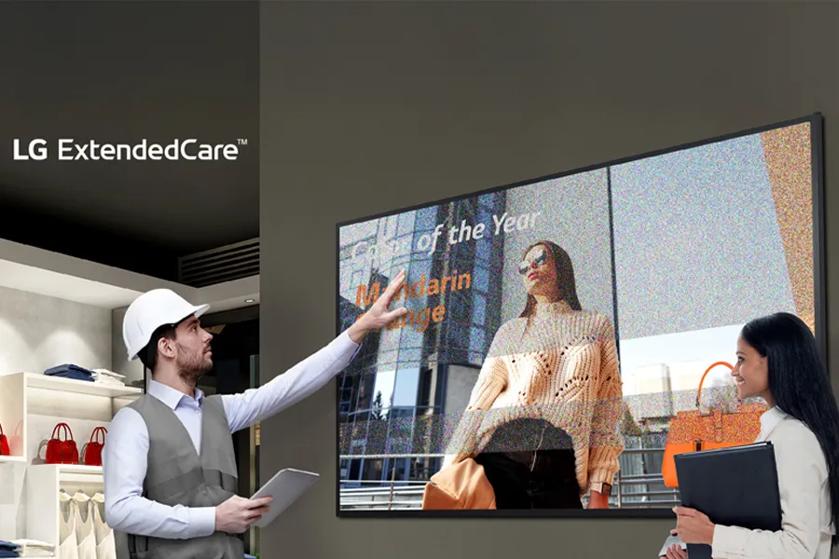 A man in a safety helmet points to a large digital display, while a woman observes, in a modern interior with shelves of handbags.

Transcribed Text:

"LG ExtendedCare™ "