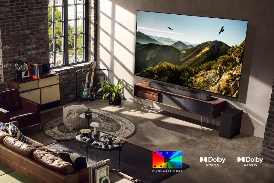 A TV in a stylish living room with two eagles soaring on-screen. FILMMAKER MODE logo. Dolby Vision logo. Dolby Atmos logo.