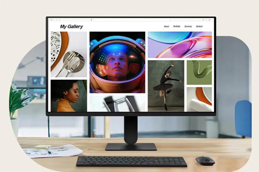A computer monitor on a desk displays a web gallery featuring diverse images and a clean layout.
