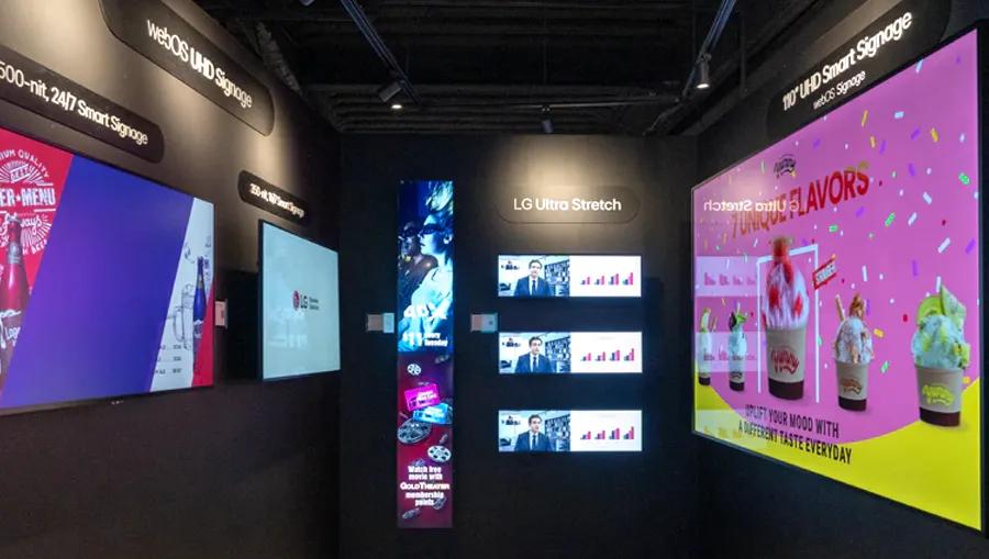 A showcase made of three black walls forming an open square, with bright signage mounted on each wall. 
