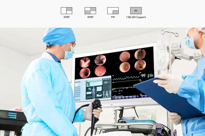 The image shows a medical setting with two individuals wearing blue surgical scrubs, masks, and hair covers. They are focusing on a large monitor displaying multiple medical images. The person on the left is holding an endoscope, suggesting they are performing or preparing for a medical procedure. The monitor shows several close-up images of what appear to be internal organs, alongside graphs and vital signs displayed digitally. Above the scene are icons labeled "3PBP," "4PBP," "PIP," "4K," and "12G-SDI Support," indicating technical features. 