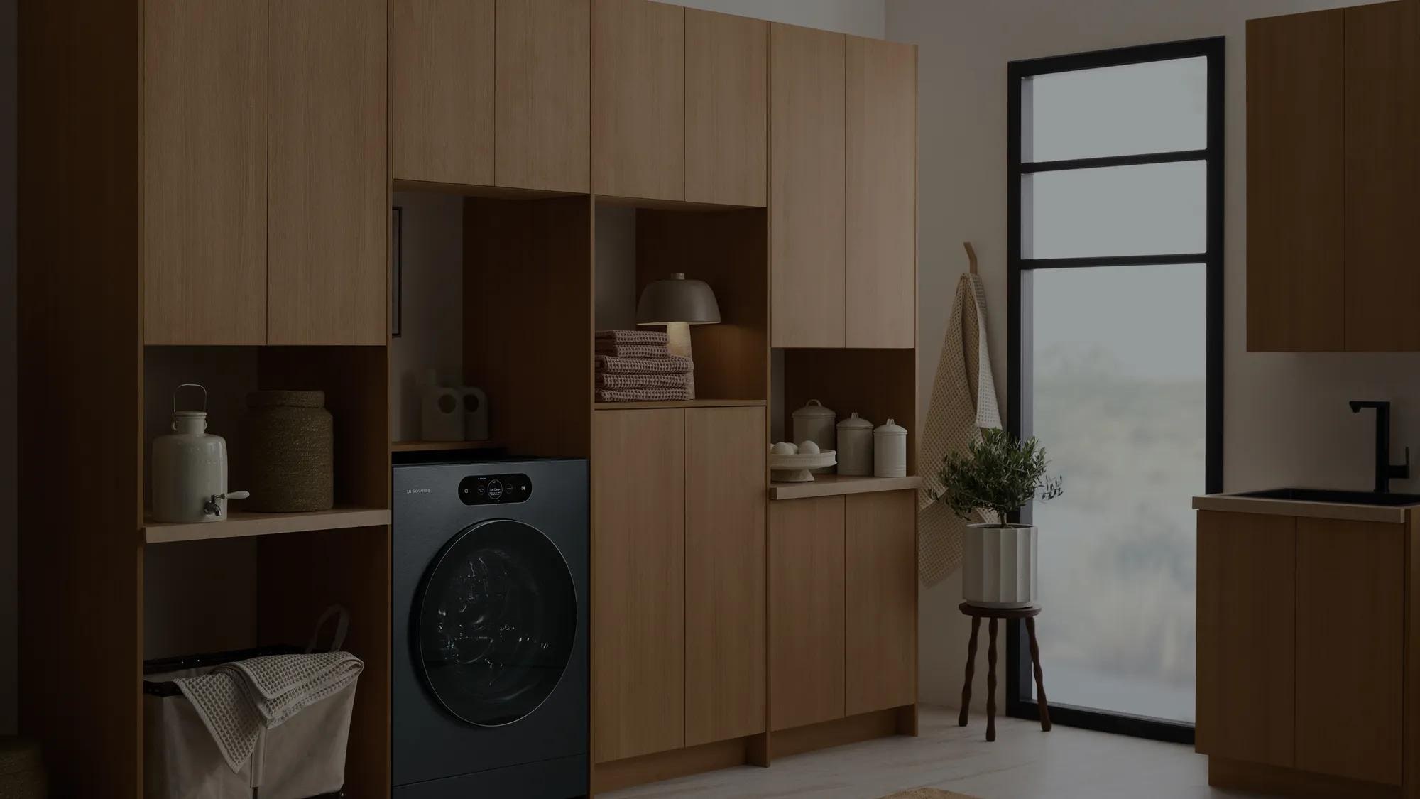 LG SIGNATURE front-load washing machine built into a laundry room with floor-to-ceiling cabinetry and natural light.