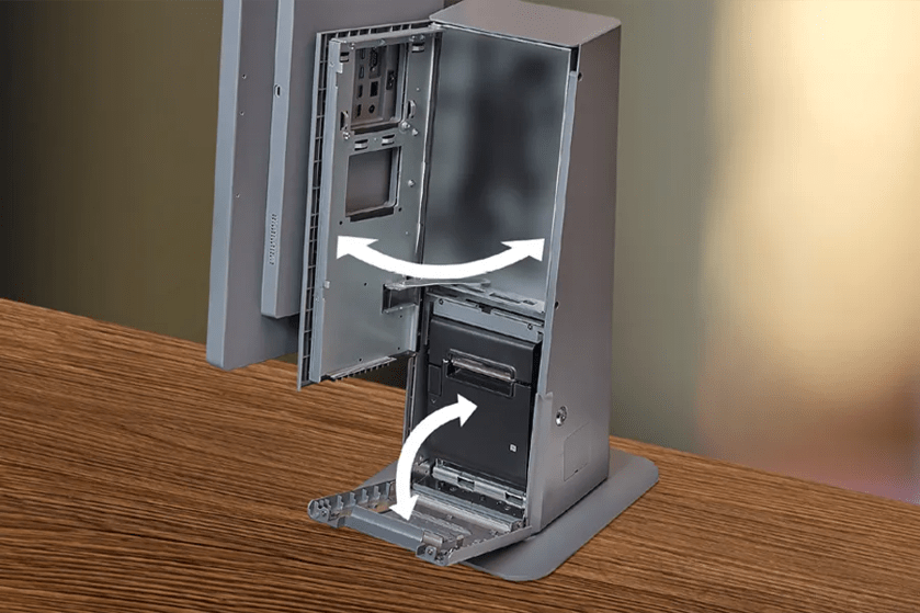 Open metallic casing on a table with arrows indicating its opening mechanism.