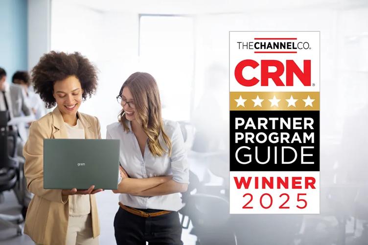 Two women stand in an office, towards the left side of the image. One of them is holding an LG gram laptop, which they're both looking at, smiling. To the right of the image is a rectangular reward graphic, reading: The Channel Co CRN Partner Program Guide Winner 2025.