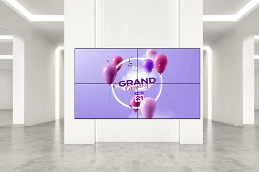 A video wall in a modern room displays a "GRAND Opening" announcement with pink and purple balloons against a purple background.