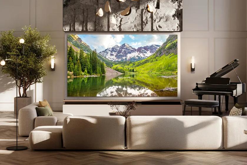 Modern living room with a large landscape artwork, a grand piano, a light-colored sofa, a floor lamp, and a potted plant.