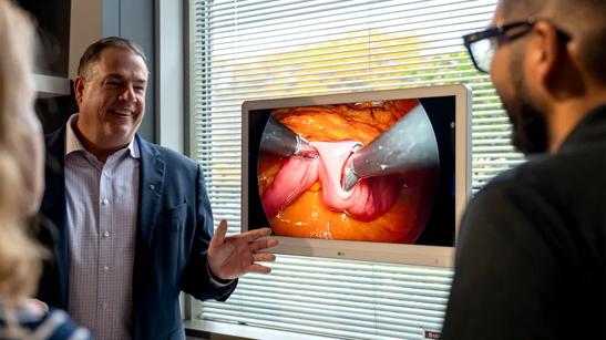 Guests admiring an LG Surgical Monitor on display.