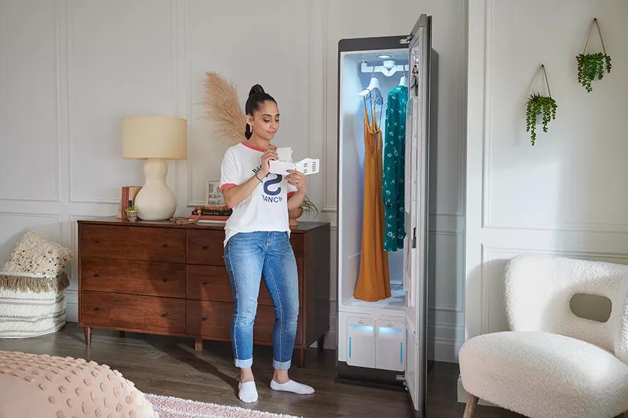 Woman adding dryer sheet to LG Styler to add a pleasant scent to clothes