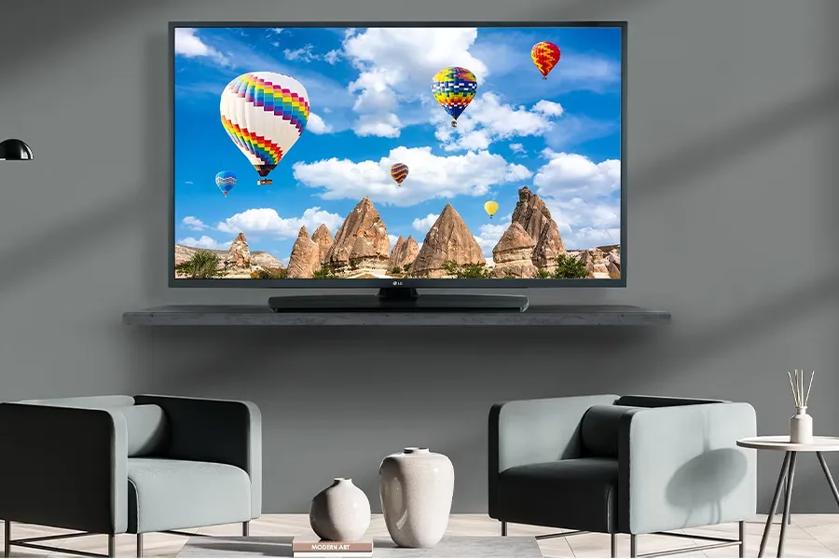 Hotel room with a wall-mounted TV displaying colorful hot air balloons.