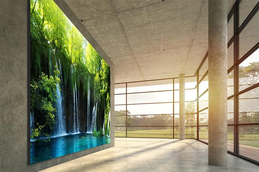 Modern interior with a large digital display of a waterfall scene and floor-to-ceiling windows.