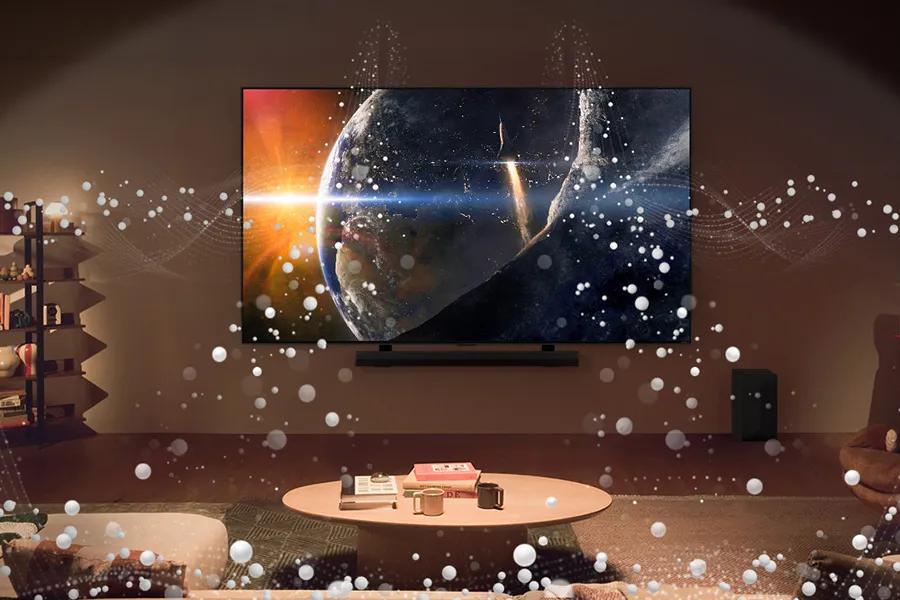 Sound waves flow from the speakers on the LG QNED99T and its compatable LG SoundBar into a living room.