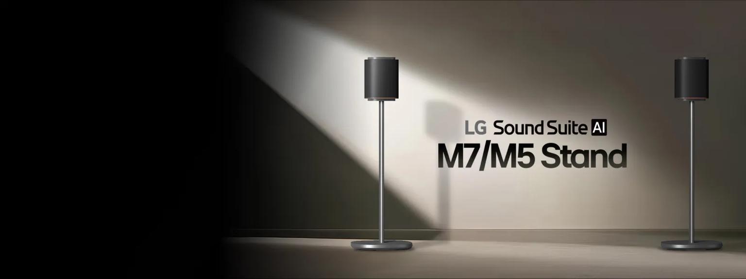 LG Sound Suite M7 and M5 speakers on stands, positioned against a softly lit wall