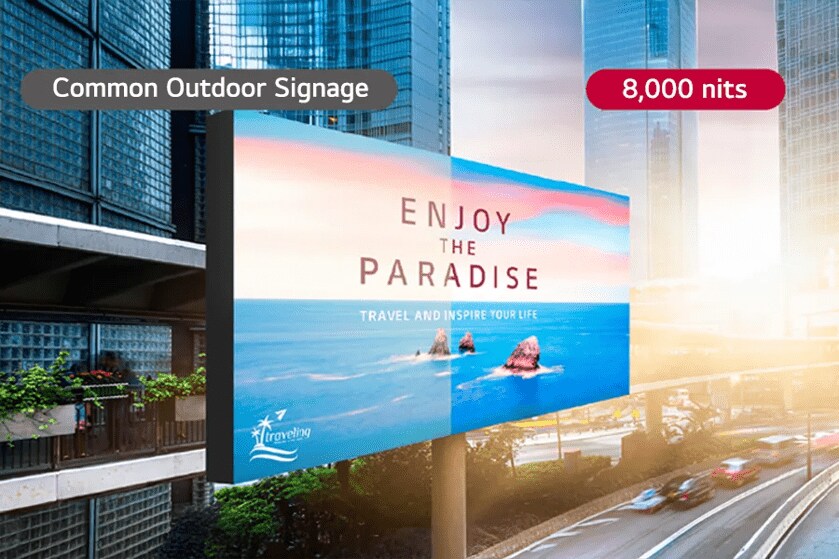 Outdoor digital display showing a travel advertisement with an ocean view, labeled "Common Outdoor Signage" and "8,000 nits."