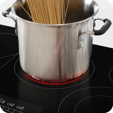 Pasta boils on an electric cooktop with visible red rings.