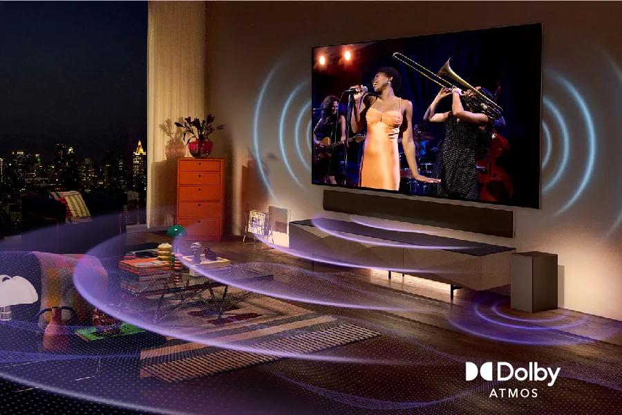 A singer on-screen with sound waves reverberating from the TV and sound bar. Dolby Atmos logo.