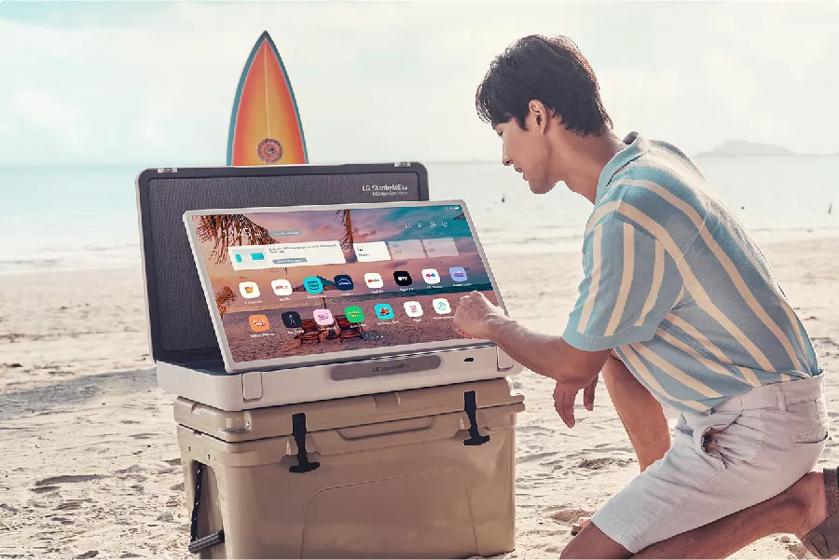 A person uses the touchscreen at the beach.