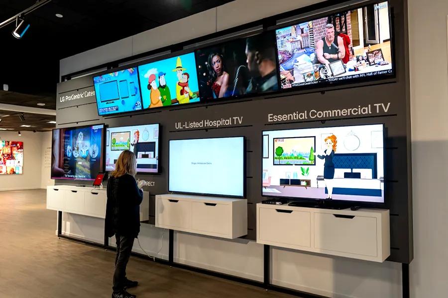 A guest looking at LG Chicago BIC's display of hospitality TVs and signage