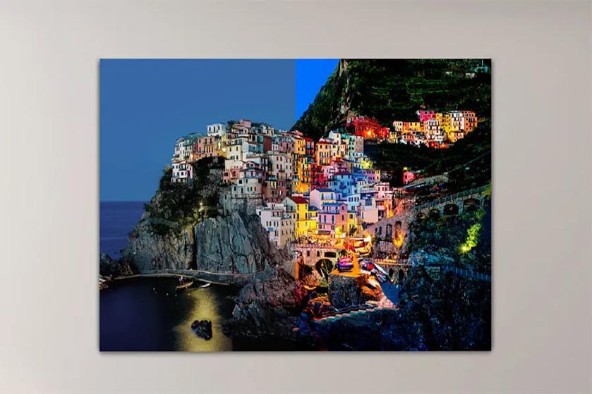 Coastal village on cliffs, split view between twilight and night.