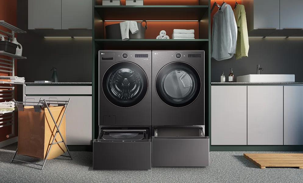 A black LG front load washer and LG front load dryer are in an industrial-styled laundry room with dark-colored accents.