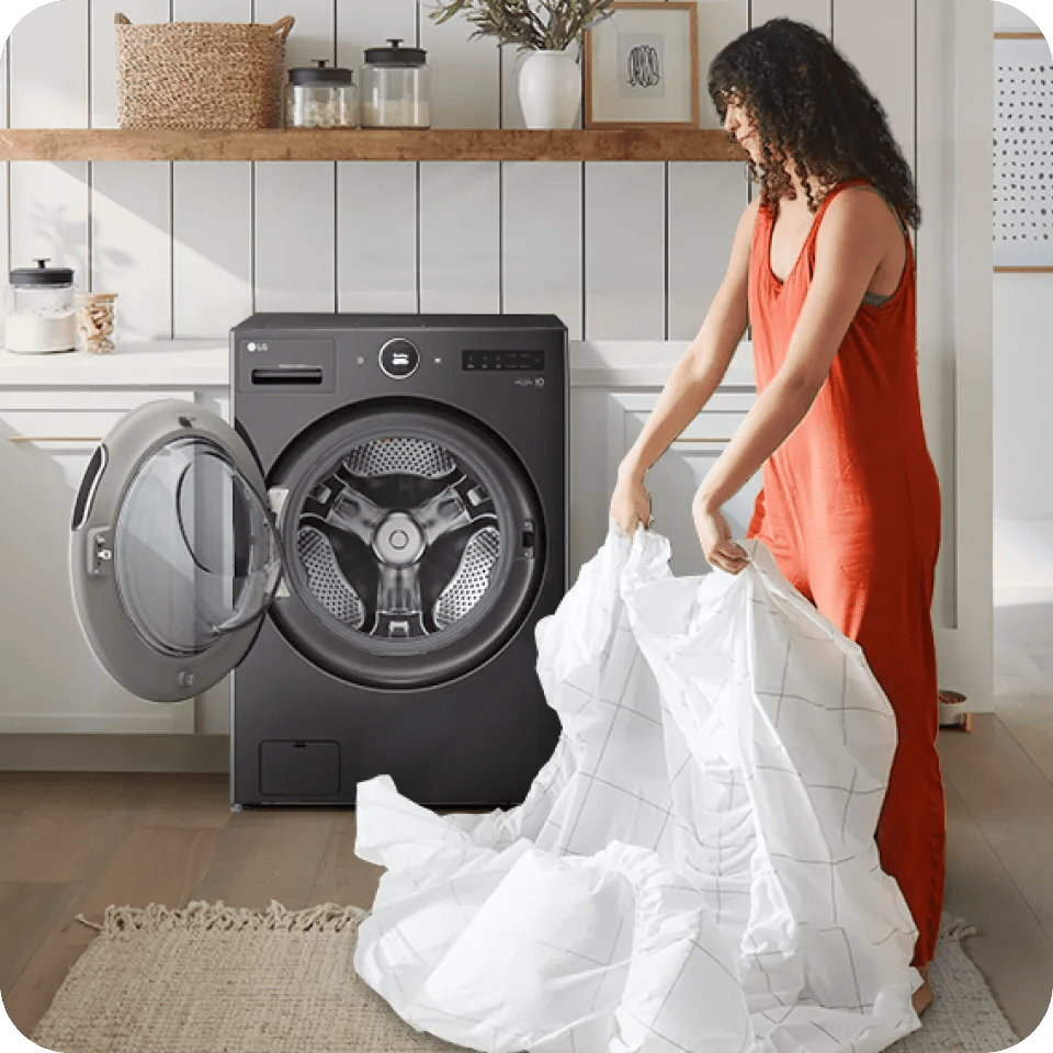 A woman shakes out a sheet after drying in an LG WashCombo™.