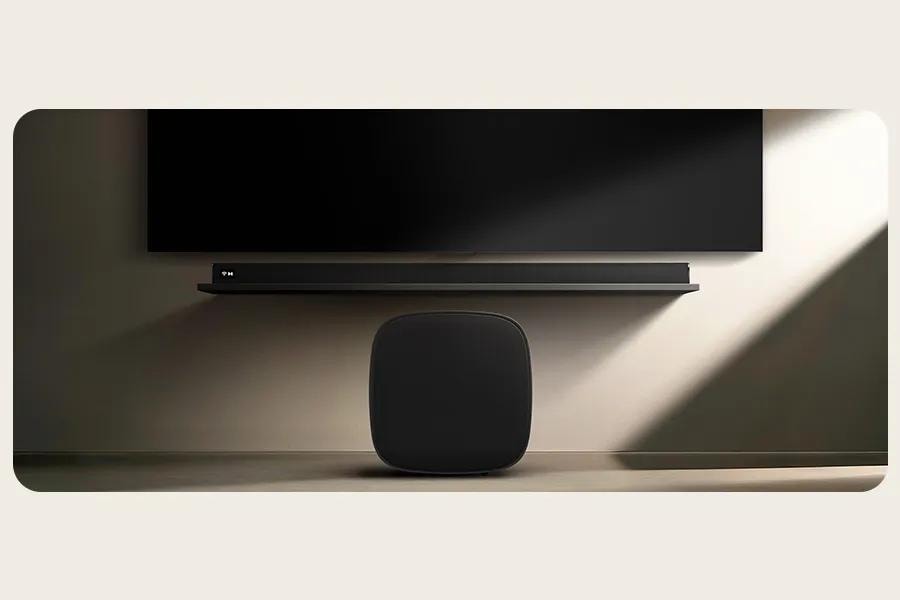 Image of the LG Subwoofer and the Soundbar next to a tv with darker moodlighting
