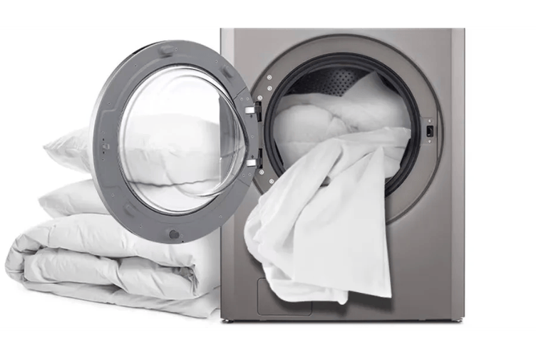 LG TCWM2013QS3 Commercial Washer with door open showing white bedding inside drum and folded linens beside unit