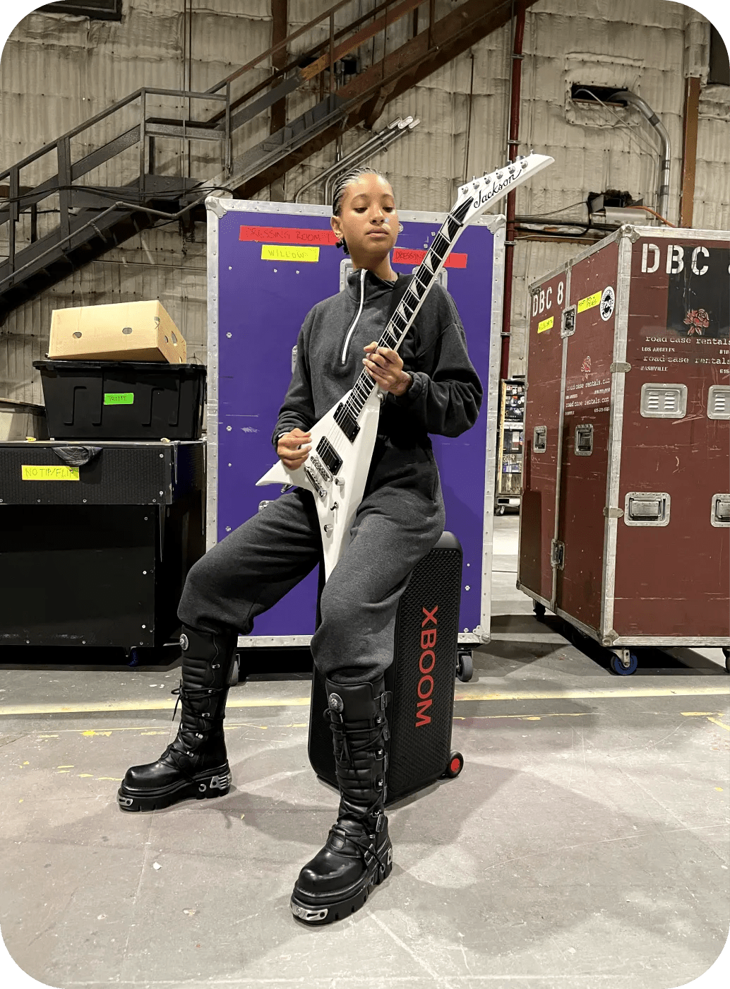 Willow Smith sitting on LG XBOOM playing guitar.