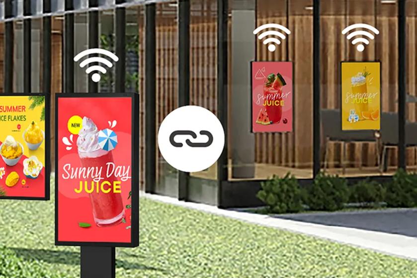Digital displays showing advertisements for Sunny Day Juice and Summer Juice, with Wi-Fi symbols above them.