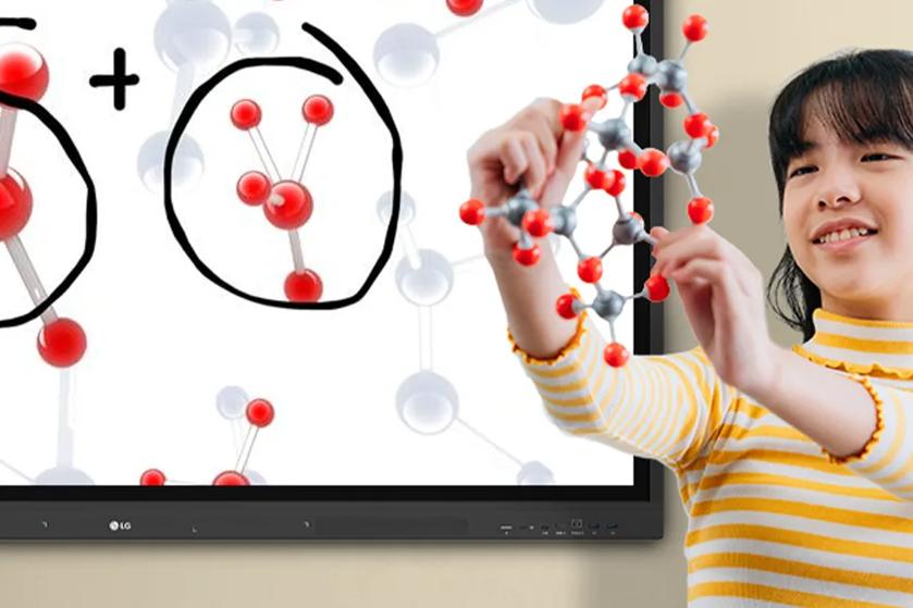 A student works with a model of molecules. Molecular structures are also displayed on the CreateBoard display behind her.